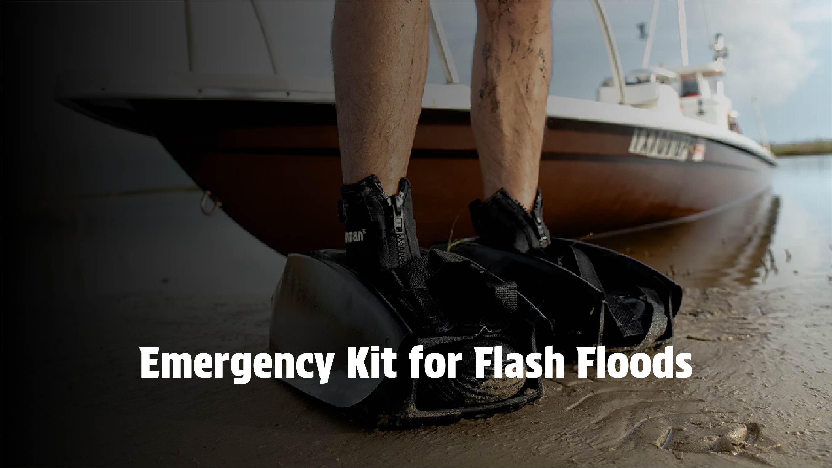 Close-up of Mudder Boots on a person's feet standing by a boat in a flash flood prone area.